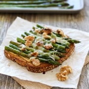 Balsamic Asparagus Hummus Toast. A light but filling vegetarian lunch of whole grain toast topped with hummus, roasted asparagus, melted cheese, walnuts and a drizzle of balsamic vinegar.