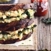 Sriracha Egg Salad Sandwich topped with flaky garlic toaster oven kale chips. A flavorful (not too spicy) cure for lunchtime boredom.